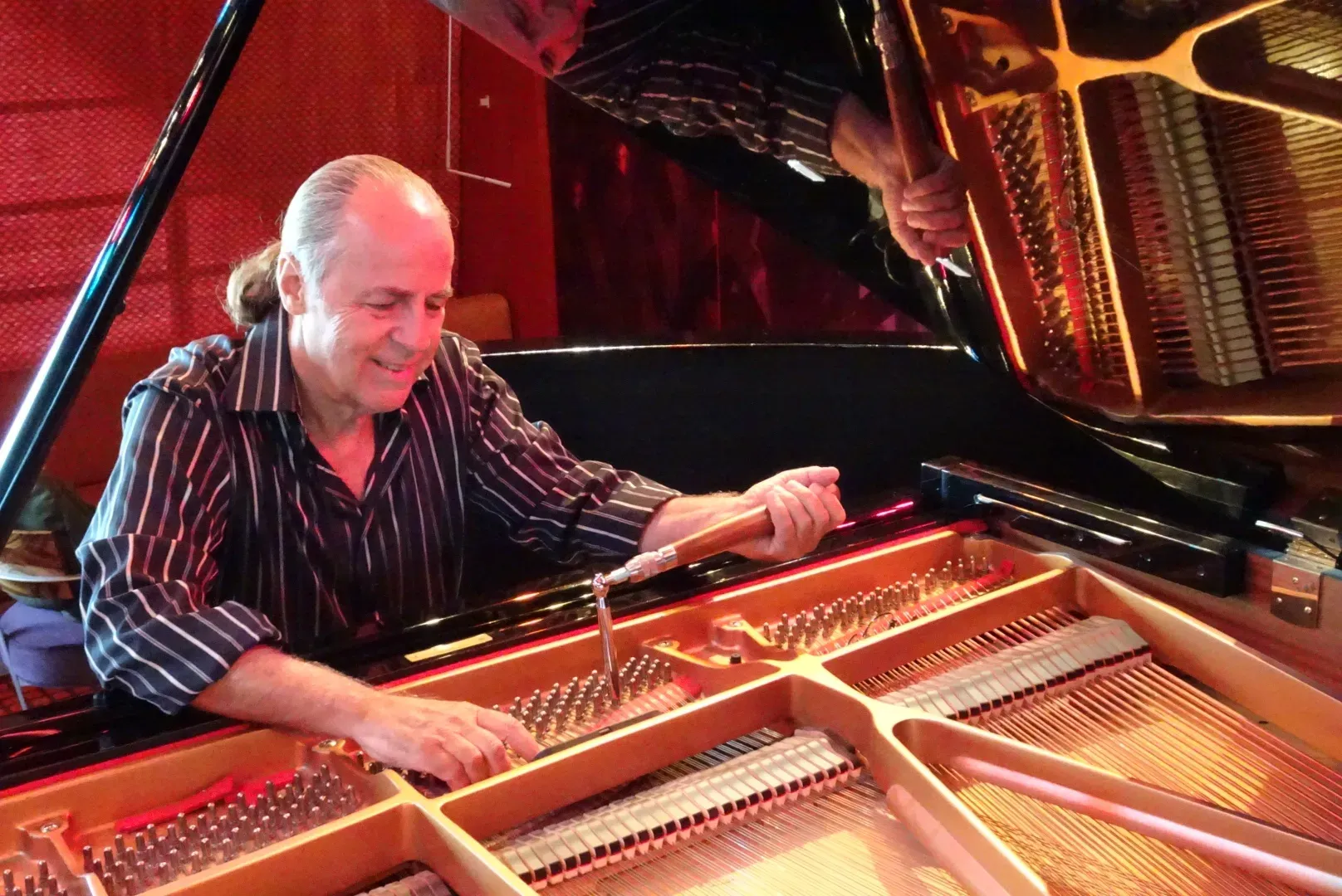 Marty Karmiol tuning a grand piano aboard a cruise ship