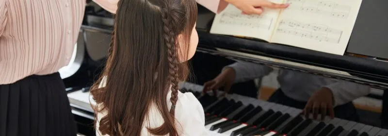 Young pianist learning proper piano care and technique